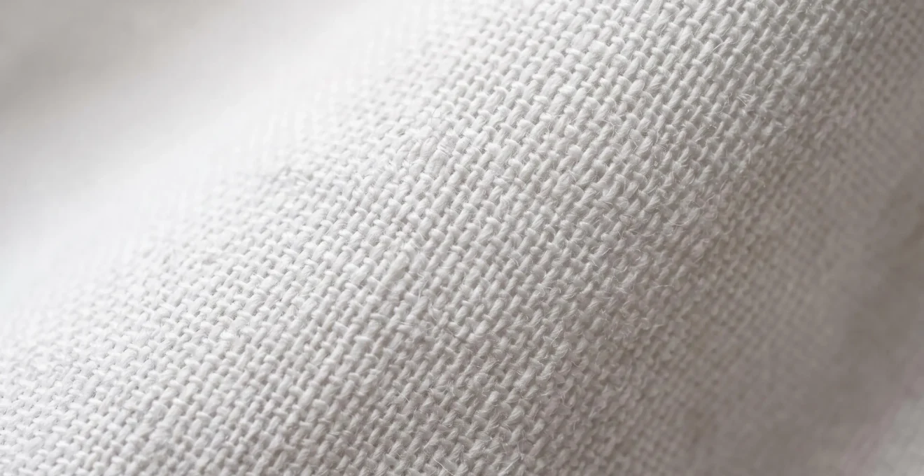 Détail macro du tissage serré et régulier d'un drap en percale de coton haut de gamme