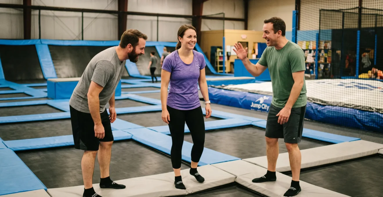 Trois collègues debout sur le bord d'un trampoline, deux personnes encourageant naturellement leur collègue avant une activité